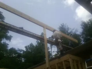 Carpenter setting a ridge beam over a new addition frame — Ice Dam Removal by Roofing Brothers in Atlantic